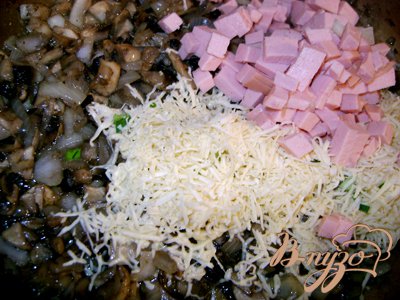 Обжарить грибы с луком, добавить колбасу и половину сыра, майонез, размешать и жарить ещё несколько минут, посолив и поперчив.
