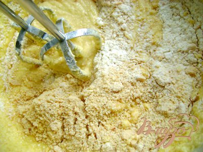 Смешать муку пшеничную, муку миндальную и разрыхлитель и добавлять в тесто по одной ст.л., непрерывно взбивая миксером на медленной скорости.