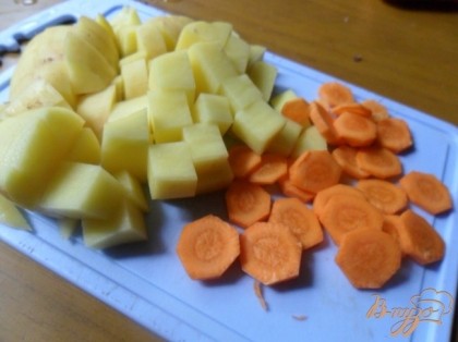 Очистить кртофель и морковь. Морковь нарезать кружочками, картофель - кубиками. Добавить в кастрюлю.