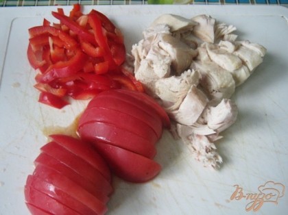 Нарезаем перец тонкими полосками, помидоры полукольцами, отварное куриное филе кусочками.