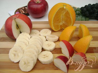 Банан нарезать на колечки примерно по 0,5 см. Вырезать из яблока и апельсина по 2 ломтика, разрезать их на 2 части(шапки для снеговичков).