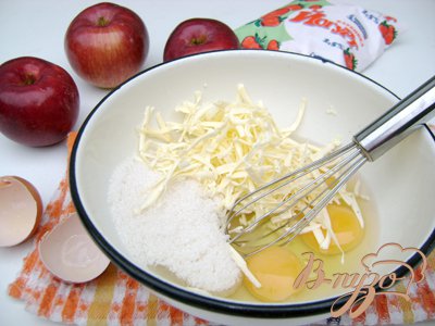 Яйца венчиком или миксером взбить с сахаром и маслом, натёртым на крупную тёрку.