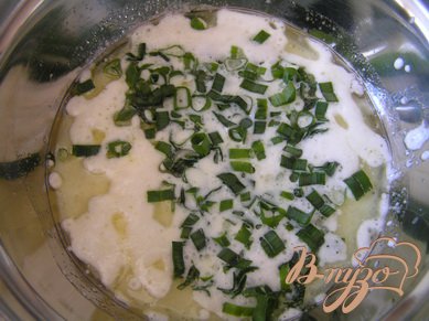 Приготовить тесто. Смешать вилкой яйца с молоком, добавить масло и разрыхлитель, затем нарезанную зелень, соль и перец. Все перемешать.