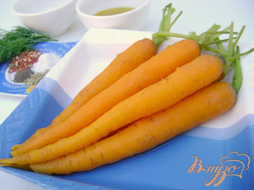 Морковь слегка почистить, оставляя зелёные хвостики, отварить до готовности (мягкости) в подсоленной кипящей воде, выложить.