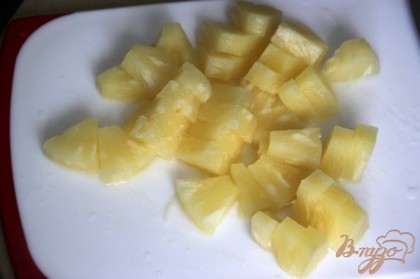 Нарезать консервированный ананас на кусочки