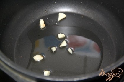На сковороде/ в глбокой кастрюле/в чугунке нагреть немного растительного масла и выложить в него зубчик мелко нарезанного чеснока .