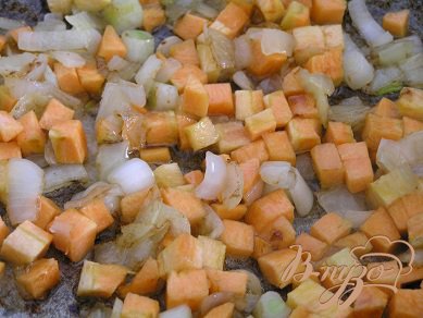 В сковороде на оливковом масле обжарить мелко нарезанный лук, добавить нарезанную маленькими кубиками морковь.