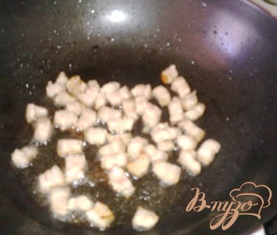 В глубокой сковороде (казане или воке) обжарить мелко порезанный бекон.