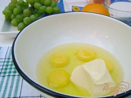 Яйца взбить со сливочным маслом. Всыпать сахар и взбить ещё раз, пока сахар не растворится. Цедру одного апельсина и сок добавить в тесто. Влить оливковое масло.