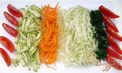 Овощи промыть, обсушить и нашинковать: кабачки - маленькими брусочками, морковь и капусту -тонкой соломкой,  перец - мелко, помидоры дольками, зелень измельчить.