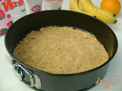 Печенье измельчить в крошку, добавить мягкое сливочное масло, хорошо размешать и выложить на дно разъёмной формы.