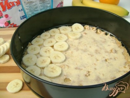 Полить сгущённым молоком. Бананы почистить, нарезать на не толстые ломтики. Выложить слой банановых колец на сгущённое молоко.