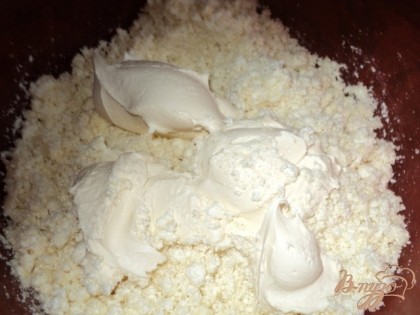 Творог смешать со сметаной, добавить соль, манку, взбитые с сахаром яйца, перемешать. Разделить массу на 2 части.