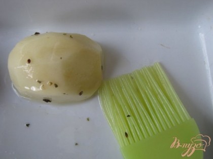 Берём удобную для запекания форму. Перерезаем картофель пополам. И кисточкой обильно смазываем ароматным маслом картофель со всех сторон, прямо над формой.