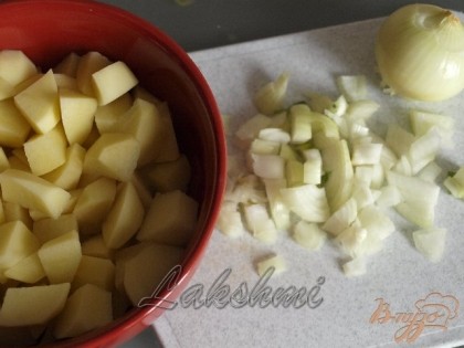 Нарезать картофель кубиками, одну луковицу нашинковать, опустить их в кипящую воду.