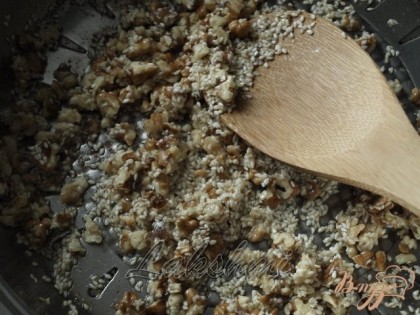 В сковороде растопить сливочное масло,обжарить немного орехи,добавить кунжут и жарить помешивая пока семена не вберут в себя всё масло.