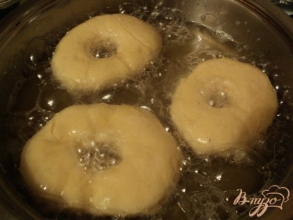 В сковороду налить растительное масло так, чтобы пончики в нем плавали, нагреть его.Жарить пончики с двух сторон до золотистой корочки.