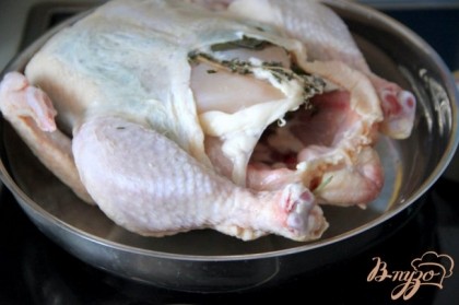 Аккуратно выложить курицу на раскалённую сковородку спинкой вниз.Поправить курицу возможности не будет, она сразу "прикипит" шкуркой к горячему металлу.И прикипевшую курицу отправить в горячую духовку на 30 мин.