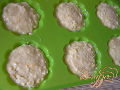 Муку смешать с кокосовой стружкой и постепенно добавляя в жидкую смесь, замесить тесто. Тесто разложить по формочкам.