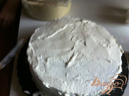 Взбить еще 200 мл сливок с сахарной пудрой (1,5 столовых ложки).Обмазать взбитыми сливками торт и выровнять при помощи сливок поверхность и боковины торта.