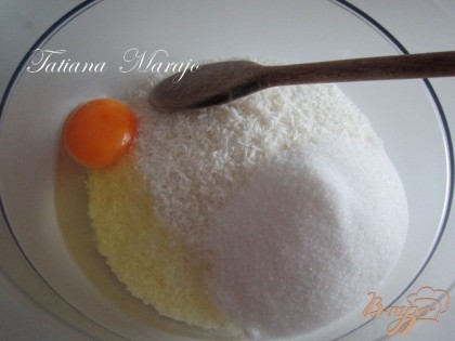 В глубокой мисочке смешать стружку с сахаром и яйцом , добавить еще 1 желток для лучшего скрепления массы.