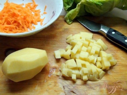 Картофель нарезаем кубиком, добавляем в бульон, пусть варится почти до готовности.Морковку натираем на тёрке, её мы добавим в последний момент.