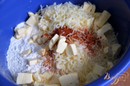 Натереть твёрдый сыр, добавить  муку, соль, паприку, порезанное на кубики ( или натёртое на тёрке ) холодное сливочное масло.