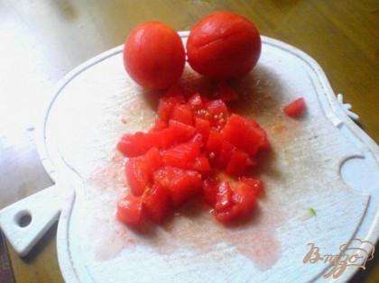 Кожицу помидоров надрезаем крест на крест. Сами помидоры погружаем на 5 секунд в кипящую воду, потом обдаём холодной водой. Снимаем кожицу. Очищенные помидоры режем кубиками.