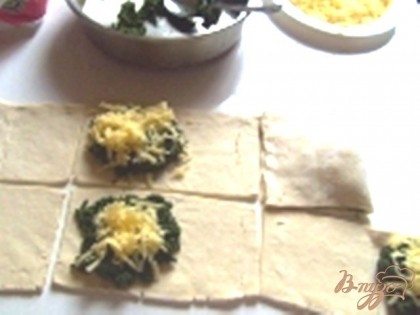 Режем тесто прямоугольниками, на одну сторону кладем шпинат и наверх тертый сыр, накрываем другой половинкой теста