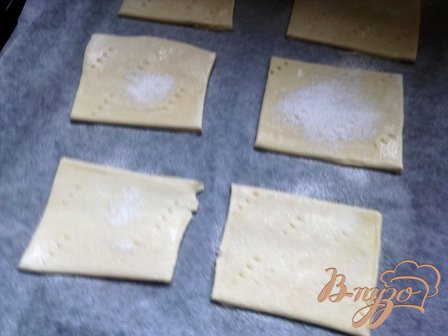 Режем на квадратики слоеное тесто и посыпаем сахарной пудрой, накалываем вилочкой и ставим в духовку на 10 минут при температуре 200 градусов