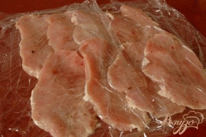 Ломтики мяса выложить на пищевую пленку и накрыть сверху пищевой пленкой. Мясо выкладывать немного внахлест.