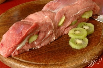 Мясо промыть, сделать острым ножом надрезы, в которые вставить небольшие ломтики очищенного киви.