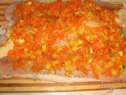 Рыбу я слегка отбила,посолила и поперчила,обжарила лук с морковью и выложила сверху на рыбу.