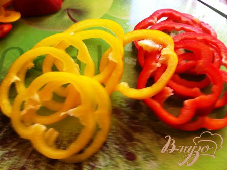 Порежьте болгарский перец кольцами (лучше выбрать трех разных цветов — это выглядит красочнее), предварительно удалив семена. Лук нарезать полукольцами, чеснок натереть на мелкой терке.