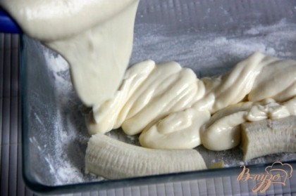 Форму для запекания смазать сливочным маслом и присыпать мукой. Выложить нарезанные бананы.Залить тестом. Запекать  в разогретой духовке ок.40 минут при 160С. Тесто сначала поднимется, но после остывания осядет. Разрезать запеканку после остывания.