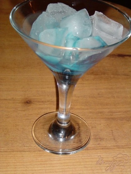 В бокал со льдом наливаем Сироп "Голубой Кюросао",