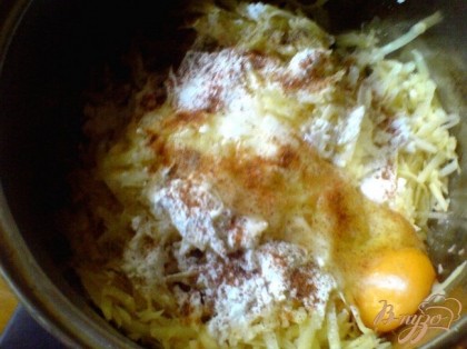 В миску добавьте лук, яйцо и крахмал. Перемешать. Приправить солью, перцем, мускатным орехом.