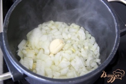 Мелко нарезать лук и расплющить чеснок. Поджарить их до прозрачности в оливковом масле.