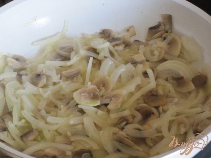 В сковороде растопить сливочное масло.  Обжарить слегка грибы, добавить лук, посолить и слегка обжарить.