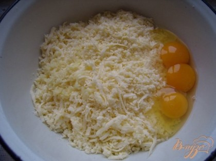 Готовим начинку.Сыр натереть на крупной терке,добавить измельченный чеснок,сырые яйца.Начинки должно получиться столько,сколько и теста.