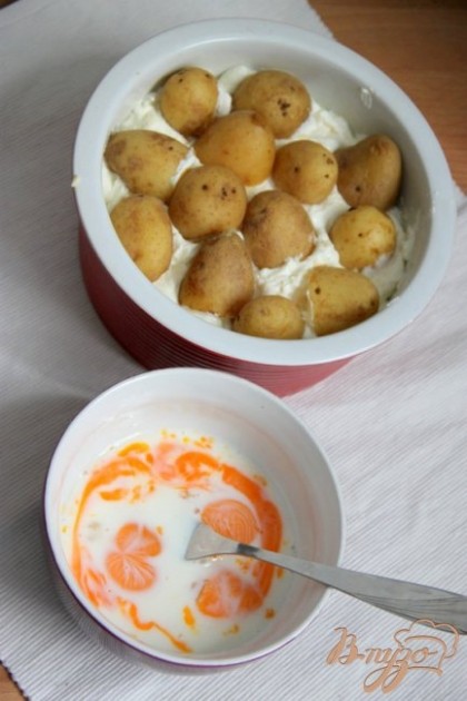 Сверху выложить оставшийся картофель (можно - половинками).Яичные желки взбить с молоком и солью.