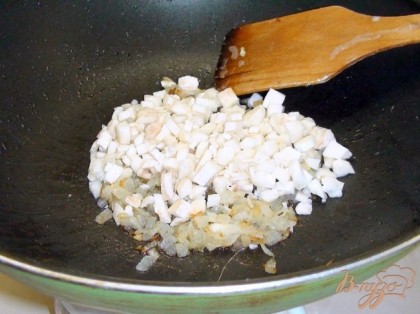 На сковороде обжарить лук до мягкости, добавить ножки от грибов. Жарим пару минут.