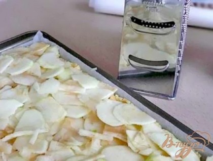 Яблоки очистить от кожи и нарезать тонкими ломтиками или настрогать на терке, выложить на тесто, сбрызнуть лимонным соком.