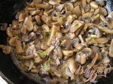 А пока приготовить начинку. В небольшой сковороде на растительном масле обжарить нарезанную нижнюю "белую" часть перьев лука, добавить нарезанные грибы, немного обжарить и тушить до готовности, посолить поперчить.