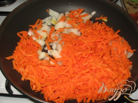 Режем лук и трем морковь. Кладем на сковородку и тушим на небольшом огне. Можно добавить немного воды вначале, пока овощи не пустят сок.