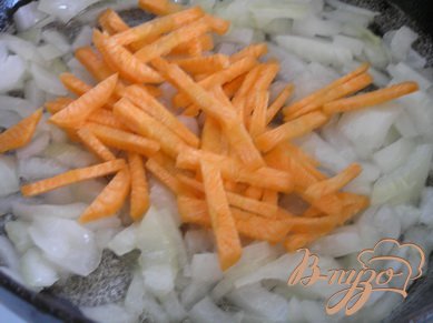 На растительном масле обжарить лук, добавить морковь и сладкий перец, обжаривать, помешивая, несколько минут.