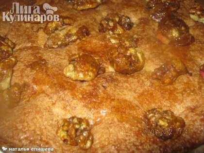 Выложить на пирог орехи, сверху можно полить малиновым сиропом, придав пирогу ещё больше вкус яблок с малиной.