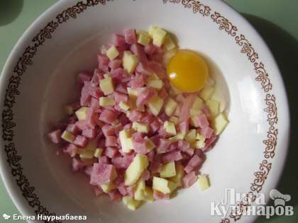 Нарезать мелко ветчину, сыр (по желанию можно добавить помидор, но не много). Влить яйцо, перемешать.