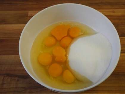 В глубокую миску разбить яйца, добавить сахар, тщательно перемешать до однородной массы