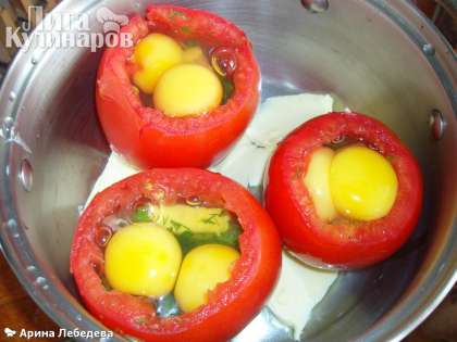Поставить яйца в кастрюльку или форму для запекания, на дно выложить кусочки сливочного масла.В отверстие каждого помидора разбить яйцо, стараясь не повредить желток. Поставить в разогретую духовку 180 градусов на 15 минут